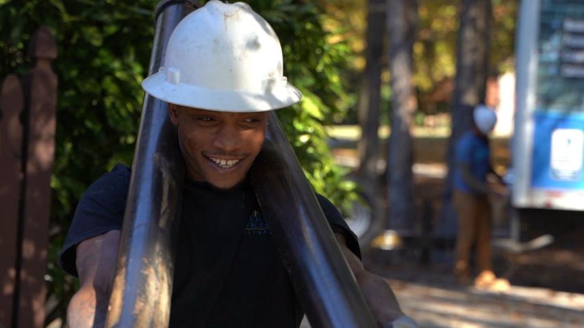 Crew carrying push piers with a smile