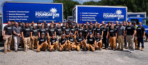 MVFS staff at Ownership Tour with supply trucks in the background.