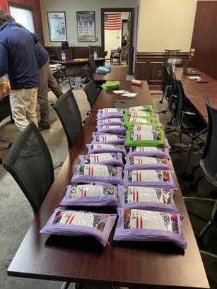 Rows of packaged snacks with American flag designs on a long table in a conference room.