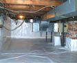 A clean, white plastic-lined crawl space with exposed wires, ductwork, and a brick support wall becomes an energy-efficient hub for your home.