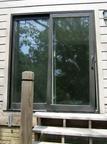 Glass sliding door installed upside down, leading to outside steps with no deck.