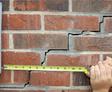 exterior stair step brick crack with tape measure