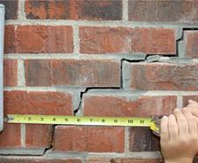 exterior stair step brick crack with tape measure