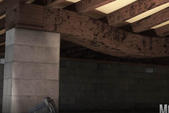 In the dimly lit basement, a wooden beam rests upon a sturdy concrete support structure, hinting at underlying floor problems.