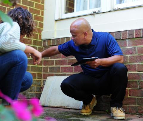 THBS CFI with homeowner inspecting brick foundation