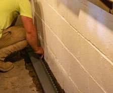 THBS crew installing interior drain in basement