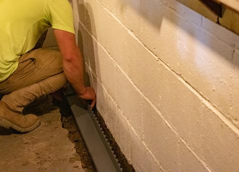 THBS crew installing interior drain in basement