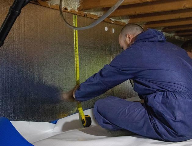 THBS is measuring crawlspace wall for a vapor barrier.