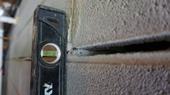 Close-up of a spirit level against a concrete wall with a horizontal groove.