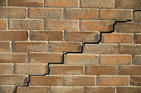 Close up of stair step cracking on brick wall