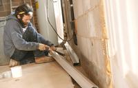 THBS crew installing interior drainage in basement