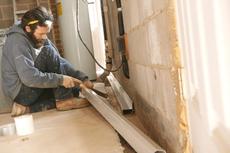 THBS crew installing interior drainage in basement
