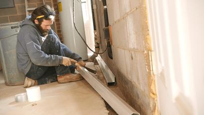 THBS crew installing interior drainage in basement
