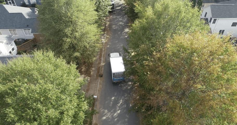 THBS supply truck driving in the neighborhood-wide shot.