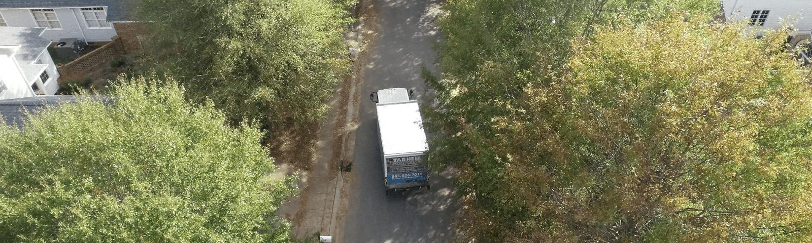 THBS supply truck driving in the neighborhood-wide shot.