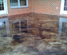 Standing water on exterior patio against brick foundation.