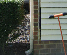 Profile shot of downspout on a brick foundation.