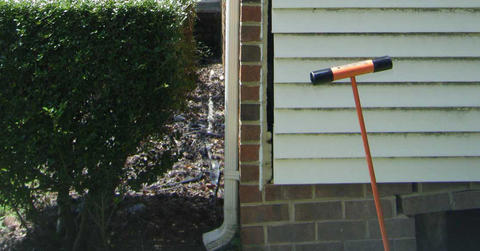 Profile shot of downspout on a brick foundation.