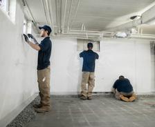 crew members installing basement waterproofing systems