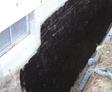Tar coating on the exterior concrete block wall.