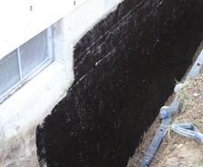 Tar coating on the exterior concrete block wall.
