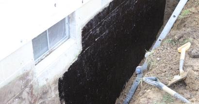 Tar coating on the exterior concrete block wall.