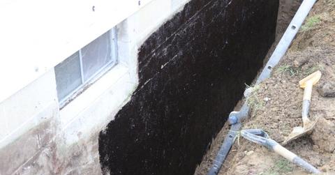 Tar coating on the exterior concrete block wall.
