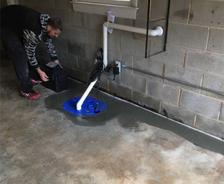 Production crew is installing a sump pump and backup battery.