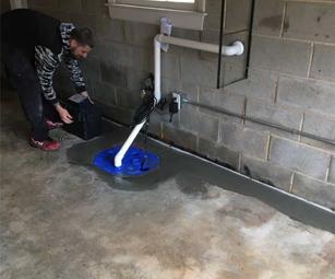 Production crew is installing a sump pump and backup battery.