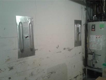 Finished wall anchors next to water heater in basement.
