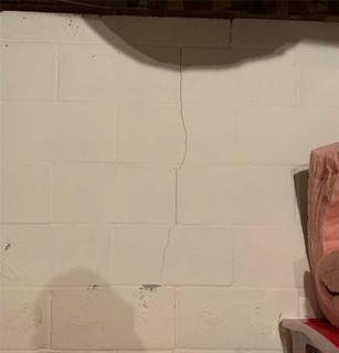 Vertical crack on the interior cinderblock wall.