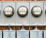Electric meters on the exterior brick foundation.