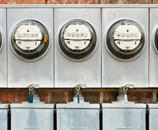 Electric meters on the exterior brick foundation.