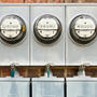Electric meters on the exterior brick foundation.