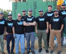 A group of people wearing matching shirts, standing together at a construction site.