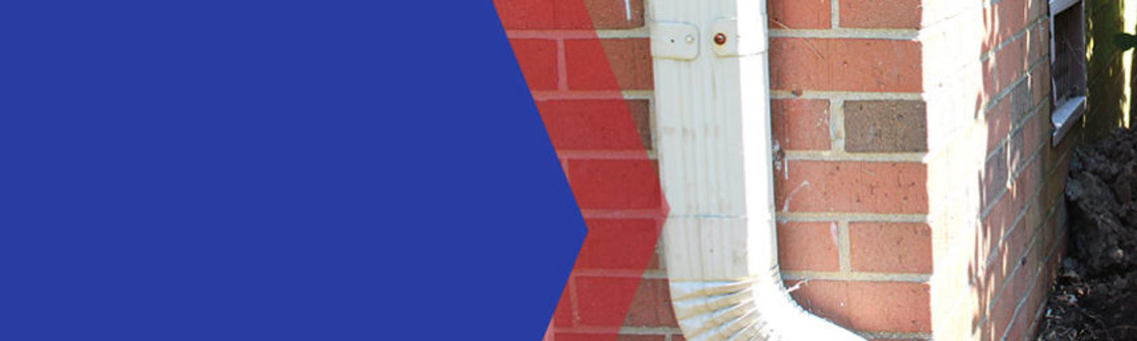 Worker wearing gloves doing brickwork on a house corner with blue and red background.