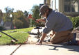 FRS crew member leveling concrete sidewalk with hammer
