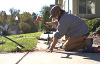 FRS crew member leveling concrete sidewalk with hammer