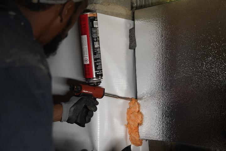 Crew installing thermal insulation with foam