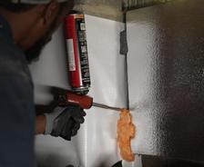 Crew installing thermal insulation with foam