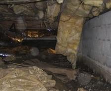 Debris and fallen insulation within crawl space