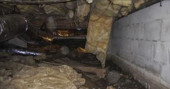 Debris and fallen insulation within crawl space