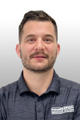 Man with short hair and beard wearing a dark polo shirt with "Foundation Recovery Systems" logo. Neutral background.