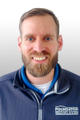 Man with a beard smiling, wearing a zip-up jacket with "Foundation Recovery Systems" logo on it.