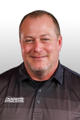 Smiling man in a black collared shirt with a "Foundation Recovery Systems" logo on it, against a white background.