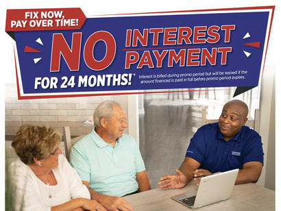 A man in a blue shirt explains financing options to an older couple at a table with a laptop.