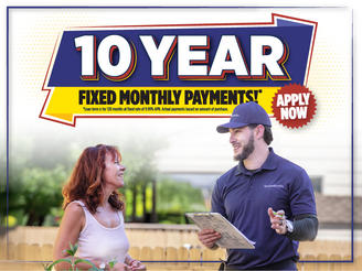 A woman talks to a man in uniform holding a clipboard, with a "10 Year Fixed Monthly Payments" sign above.