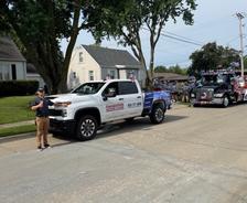 A white Foundation Repair truck and a decorated parade float featured as the start of the Urbandale 4th of July Celebration parade