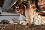 smiling crew member in a crawl space