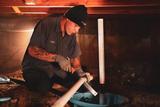 crew member in crawl space installing sump pump
